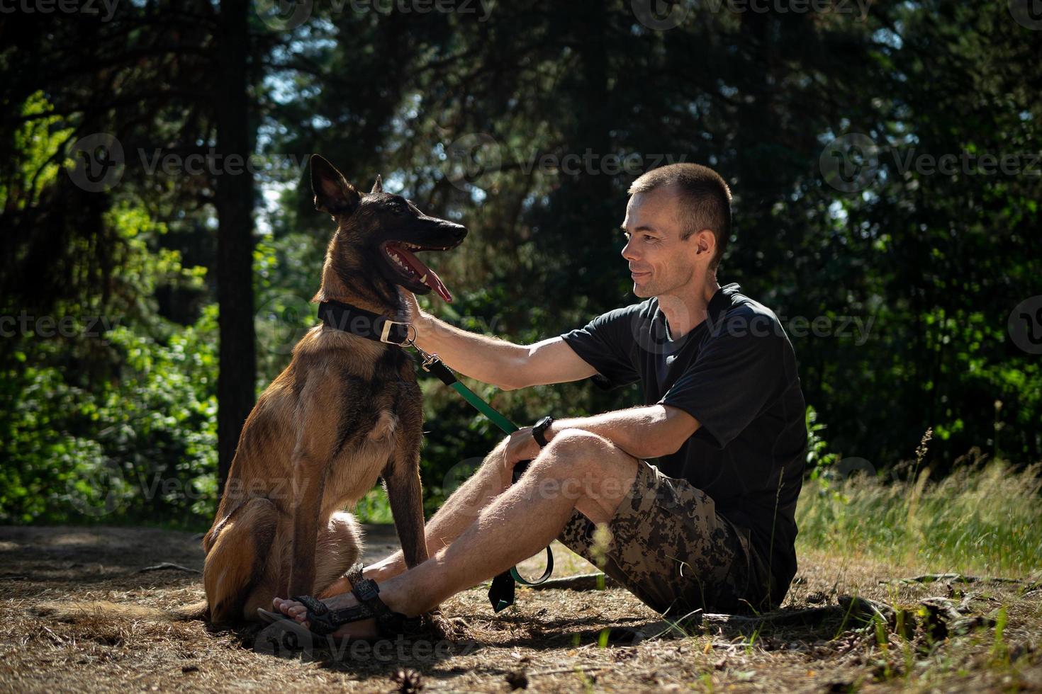 young Caucasian hipster spends time with his dog in the park on a sunny summer day. The concept of a pet as a family member photo