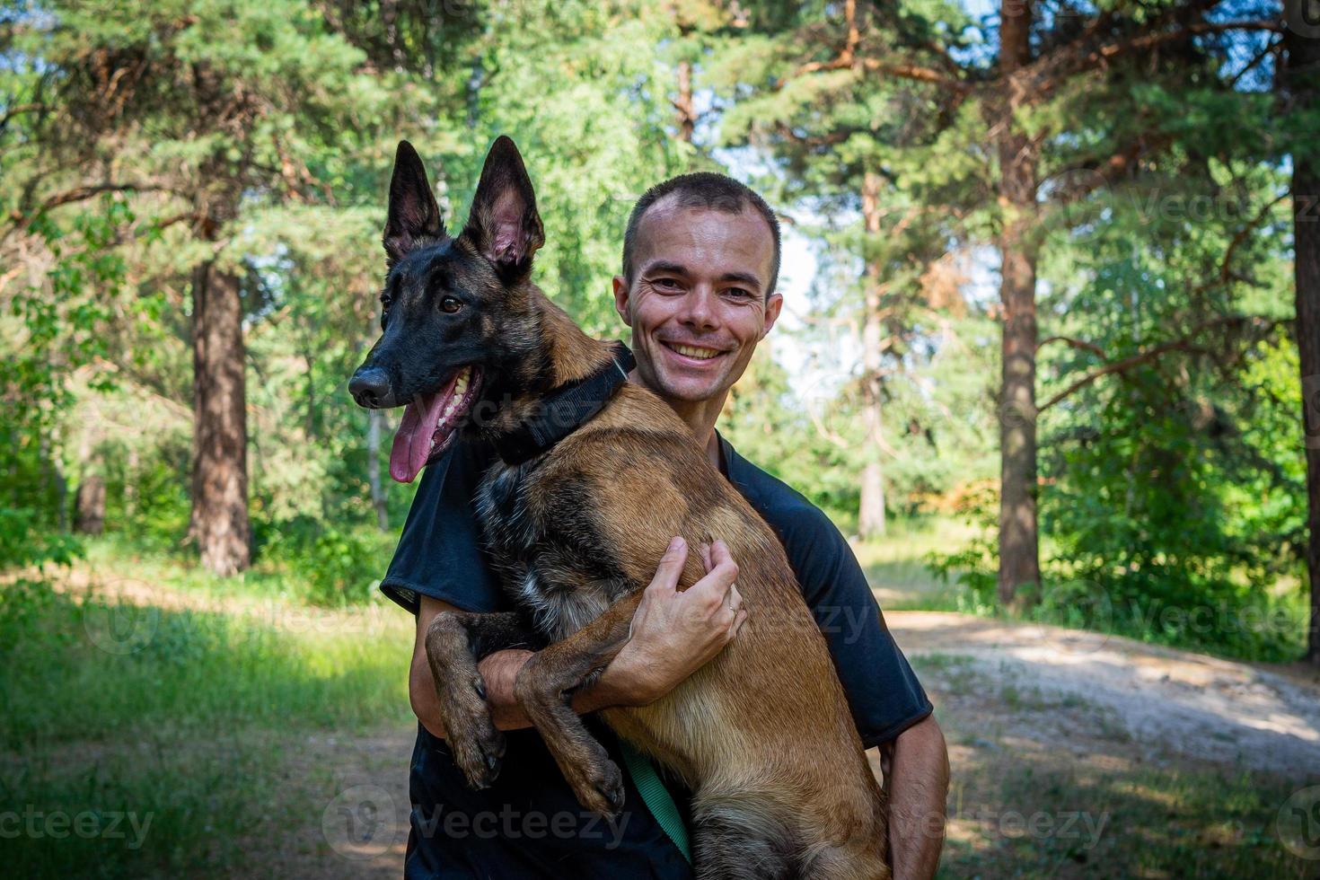 young Caucasian hipster spends time with his dog in the park on a sunny summer day. The concept of a pet as a family member photo