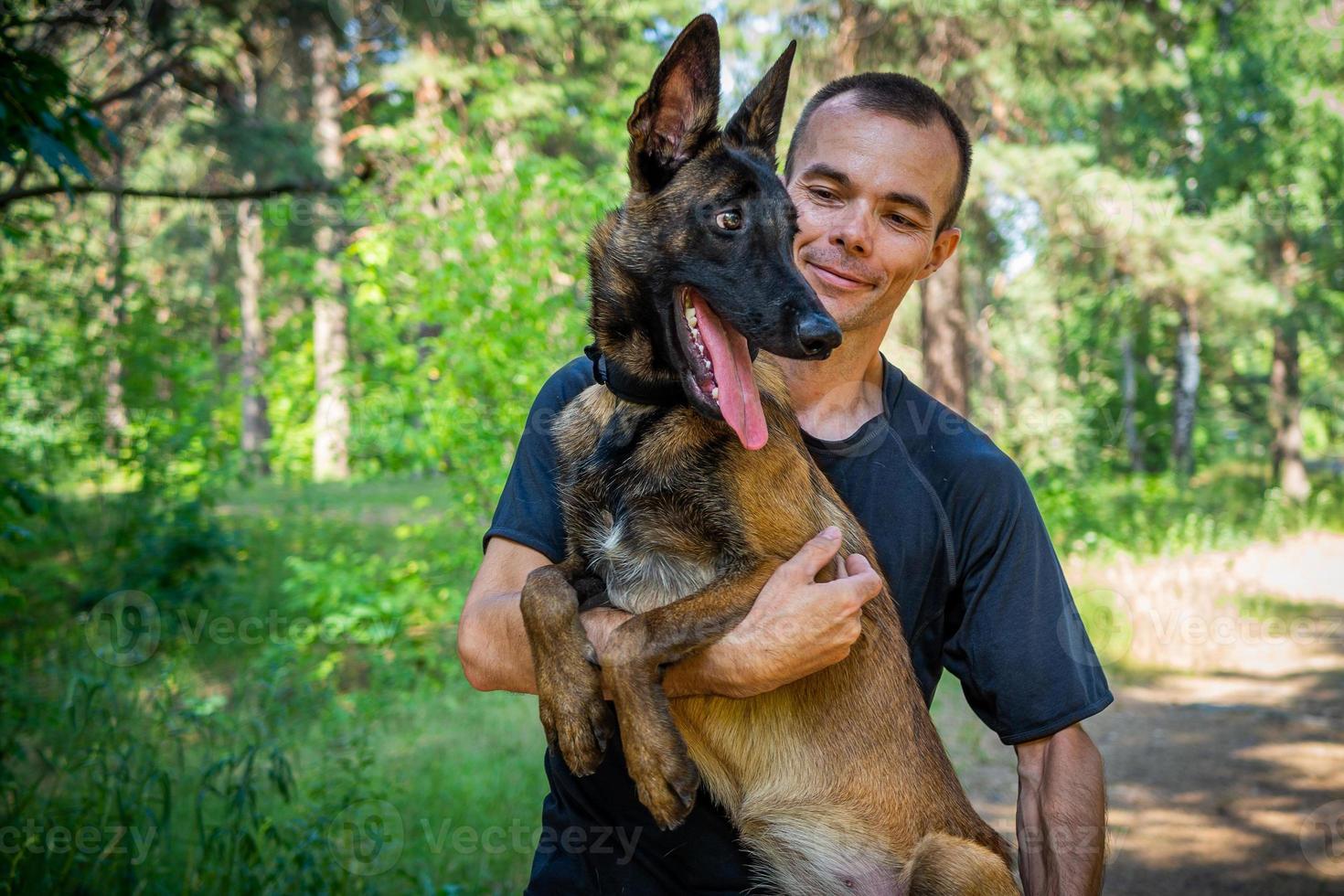 young Caucasian hipster spends time with his dog in the park on a sunny summer day. The concept of a pet as a family member photo