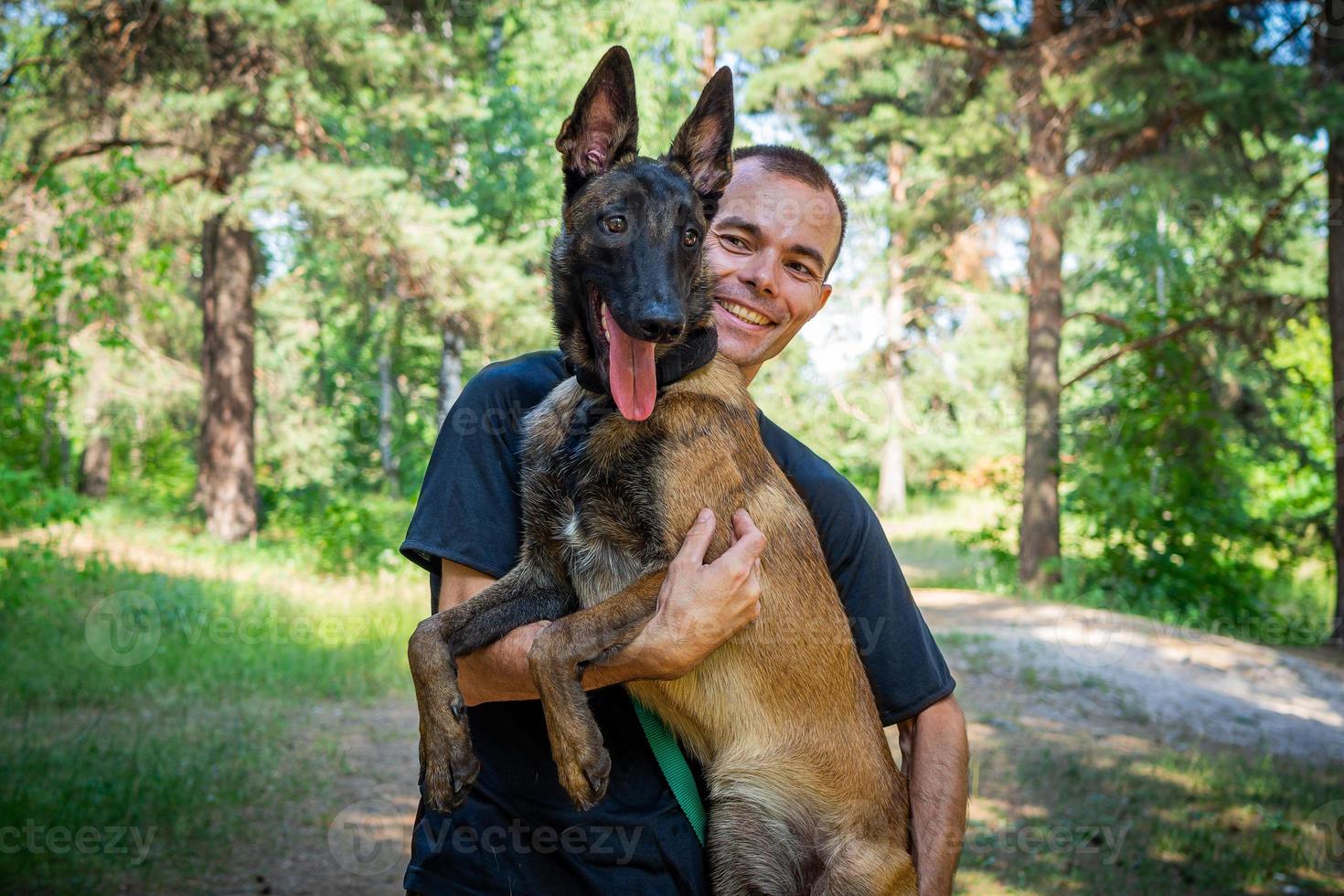 young Caucasian hipster spends time with his dog in the park on a sunny summer day. The concept of a pet as a family member photo