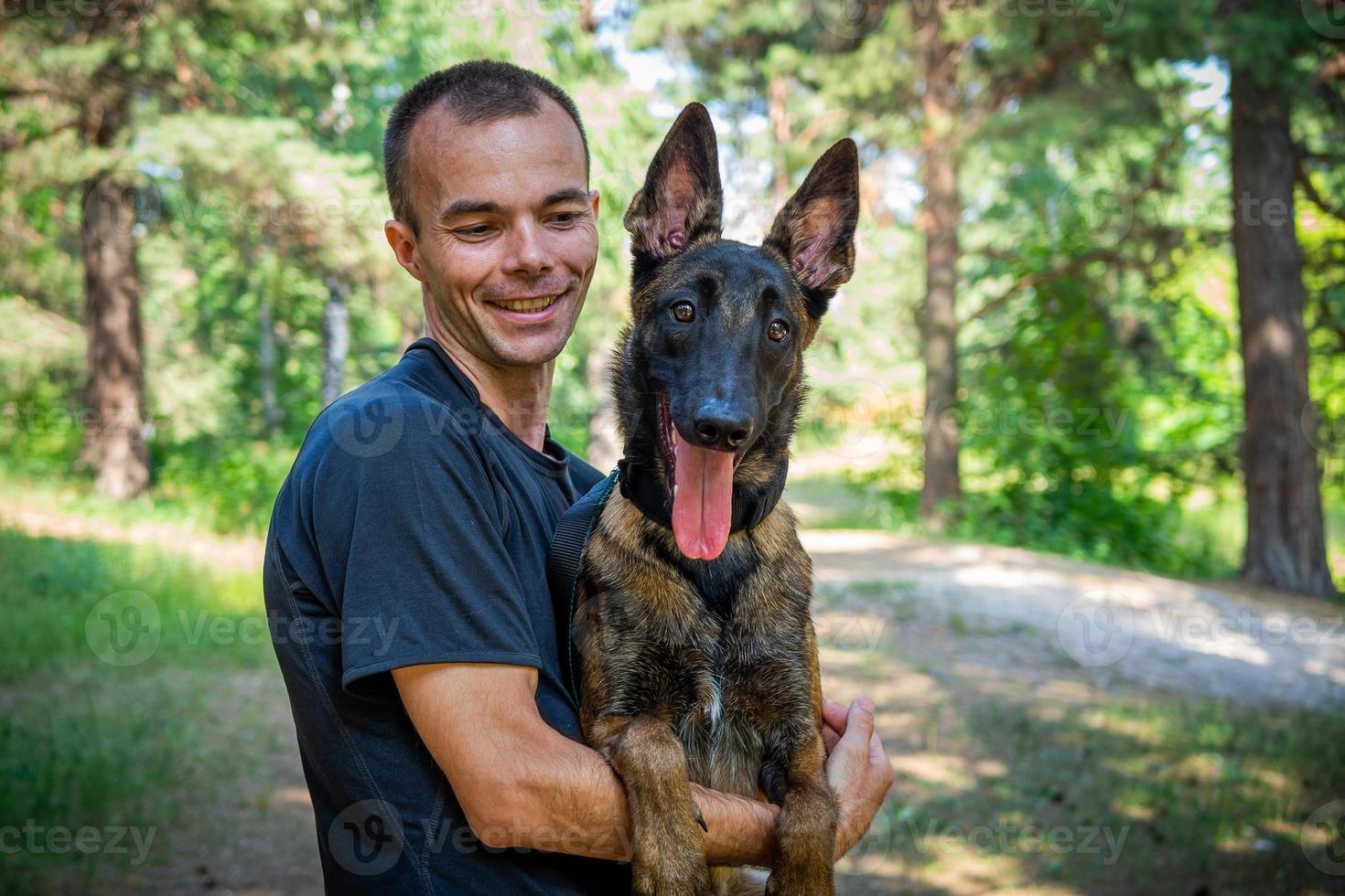 young Caucasian hipster spends time with his dog in the park on a sunny summer day. The concept of a pet as a family member photo