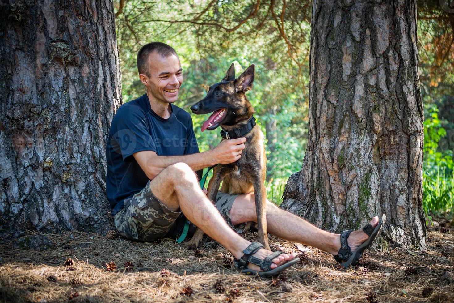 young Caucasian hipster spends time with his dog in the park on a sunny summer day. The concept of a pet as a family member photo