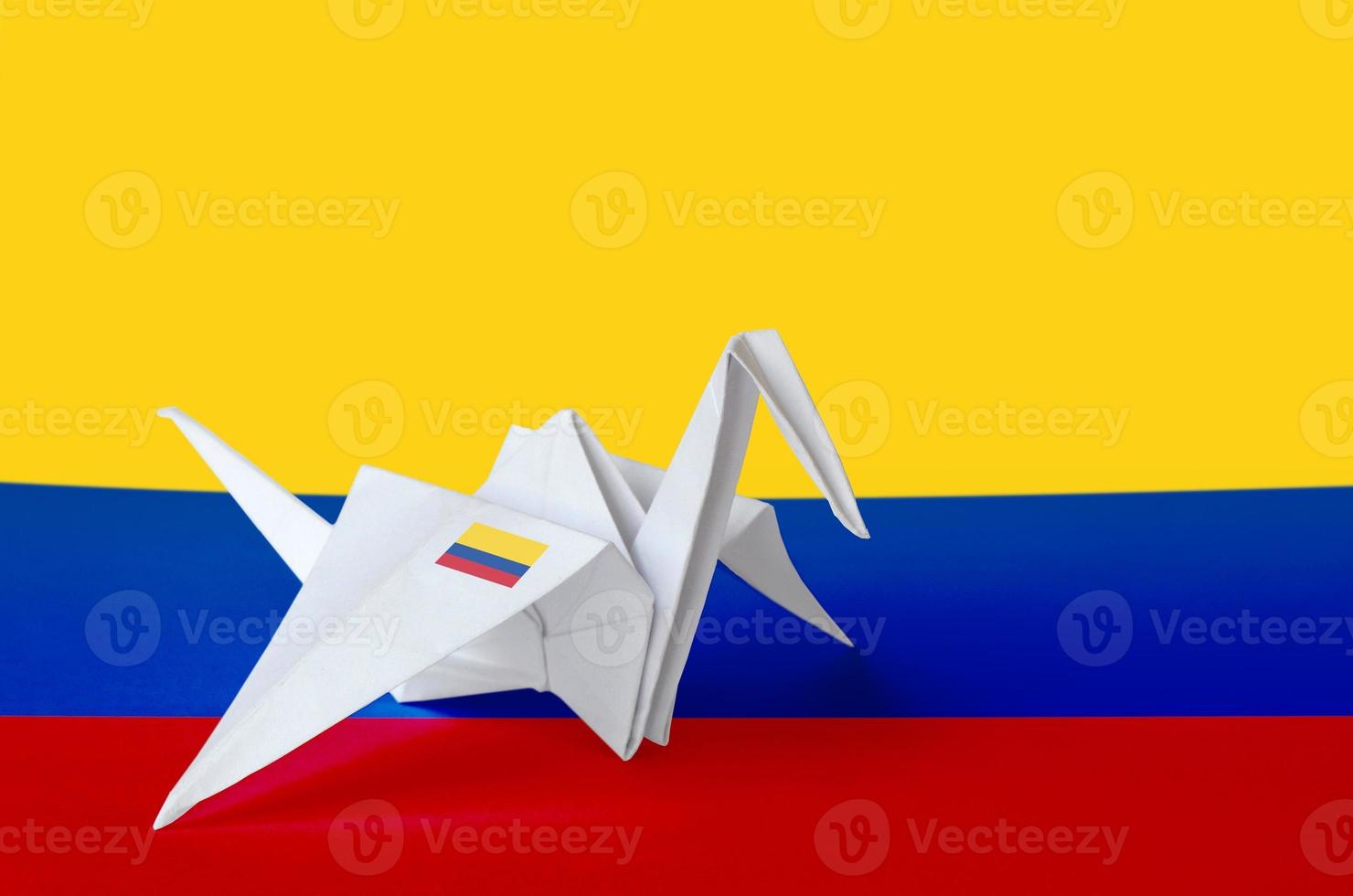 Colombia flag depicted on paper origami crane wing. Handmade arts concept photo