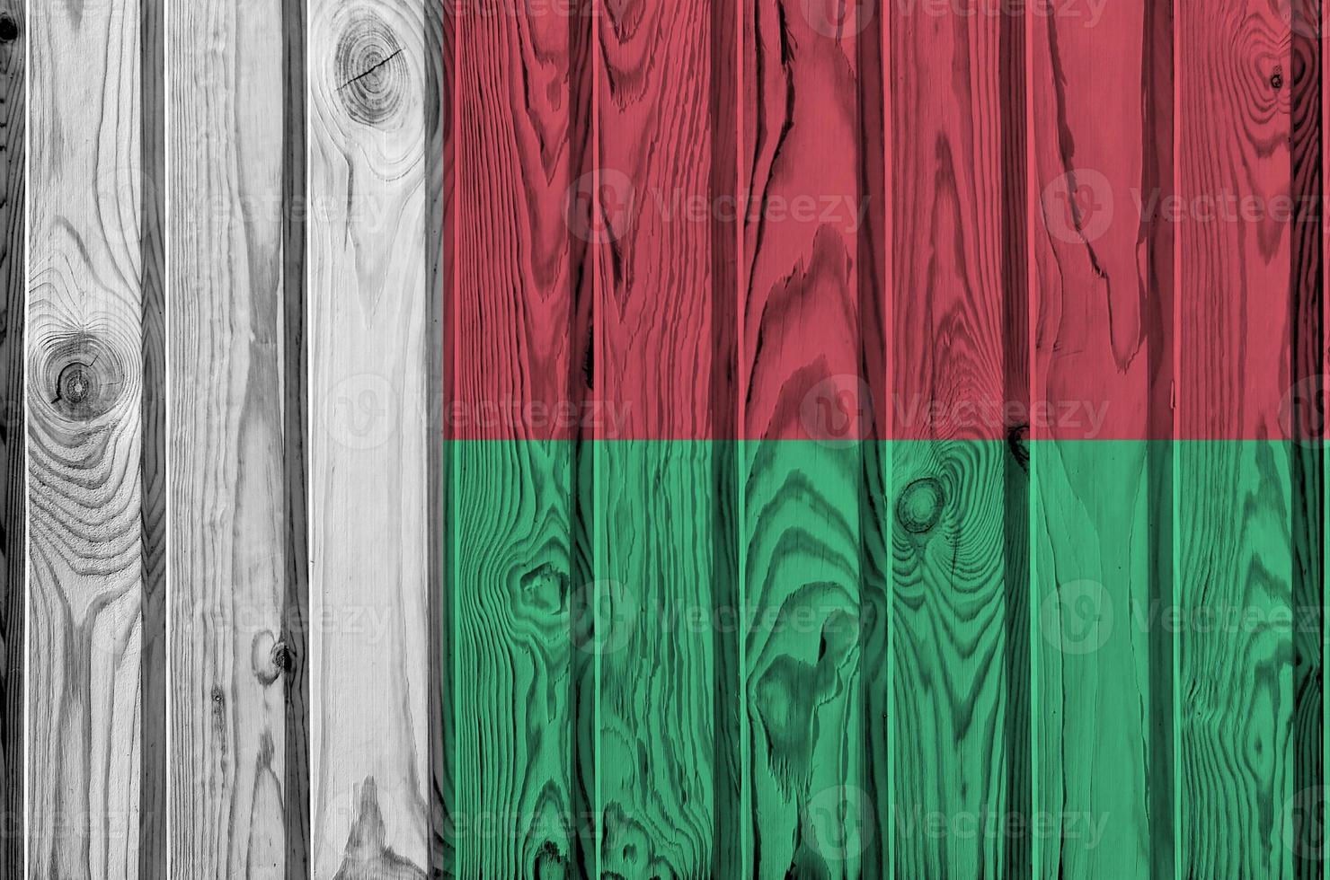 Madagascar flag depicted in bright paint colors on old wooden wall. Textured banner on rough background photo