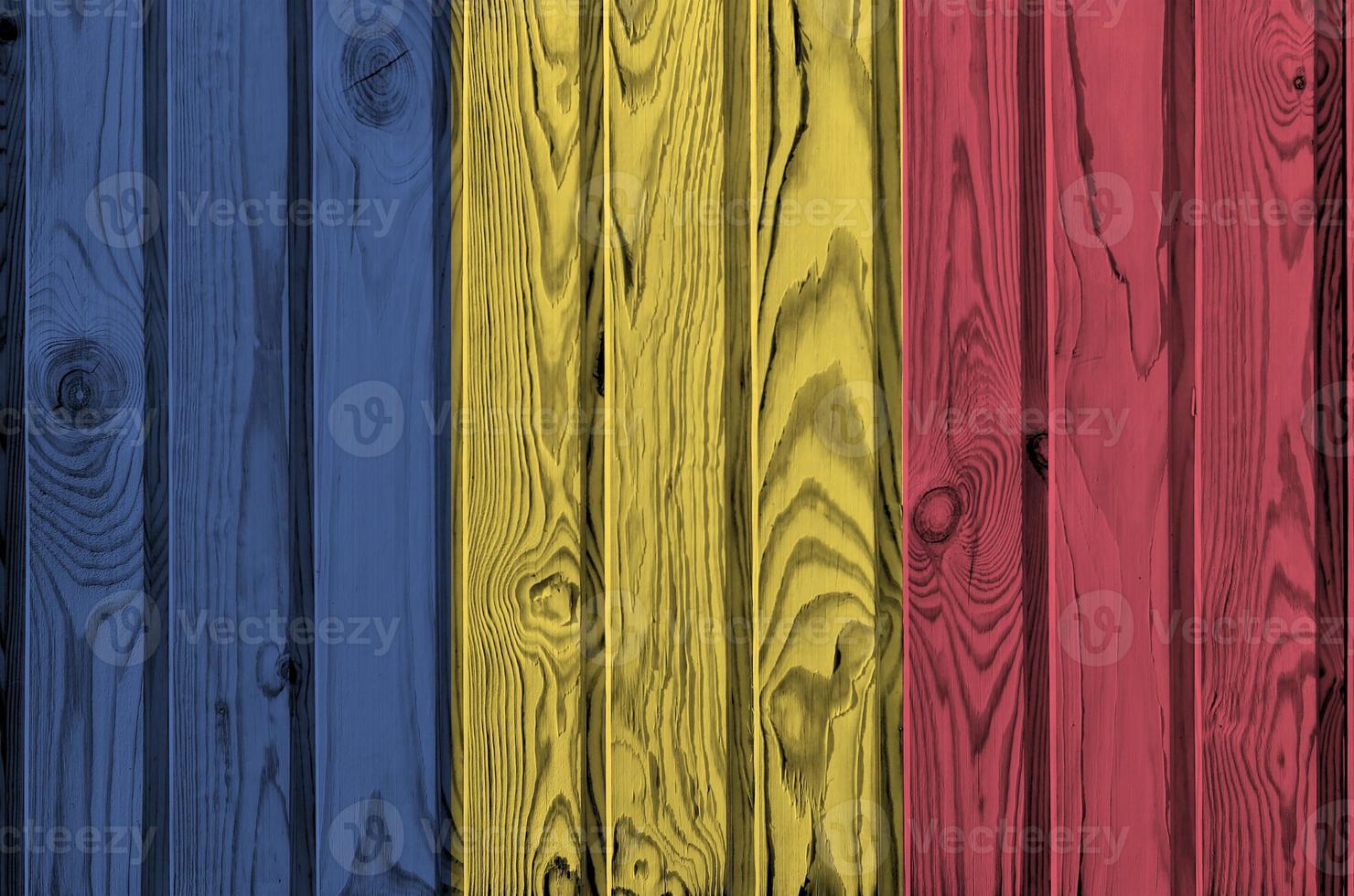 Romania flag depicted in bright paint colors on old wooden wall. Textured banner on rough background photo