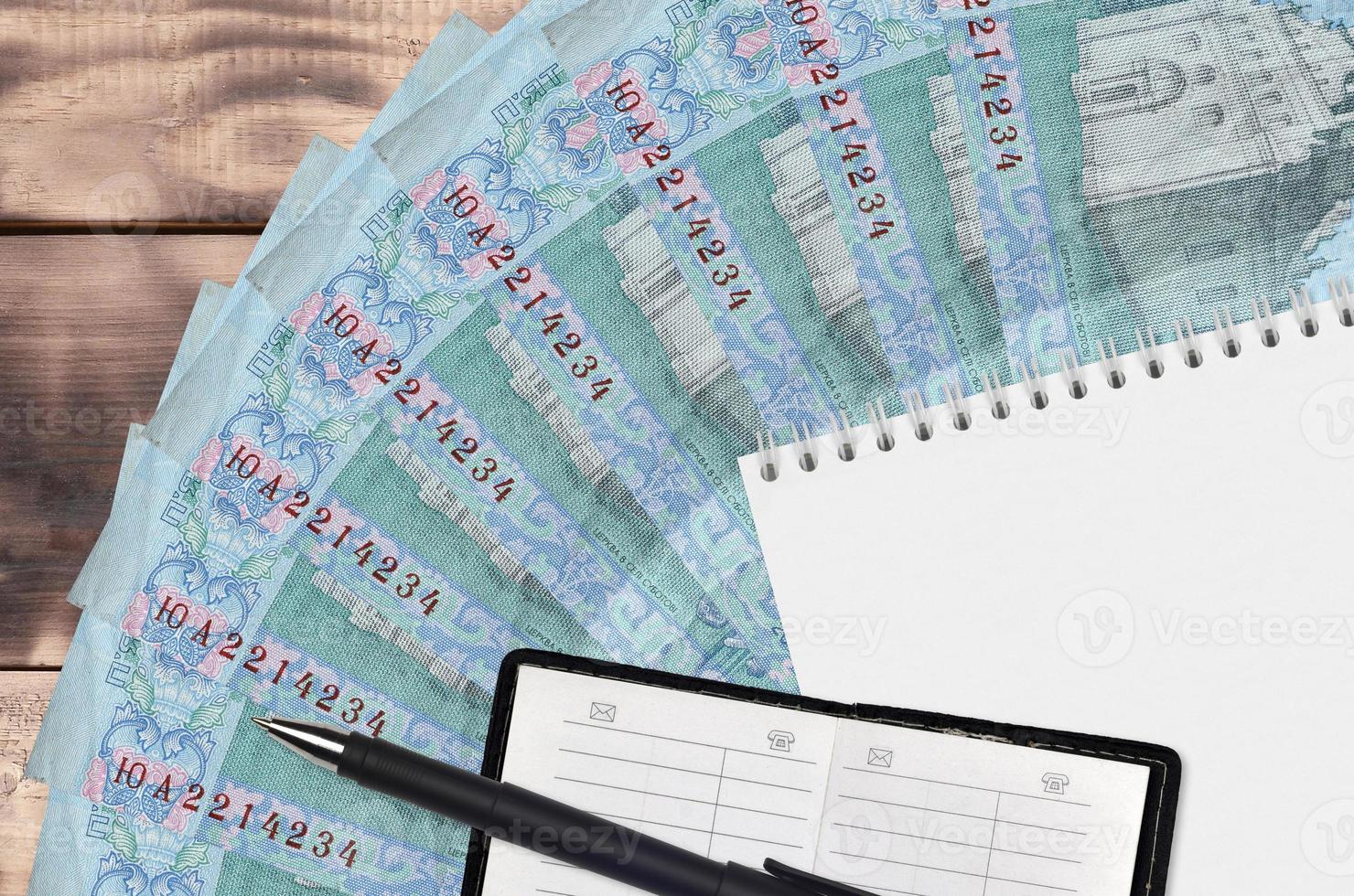 5 Ukrainian hryvnias bills fan and notepad with contact book and black pen. Concept of financial planning and business strategy photo