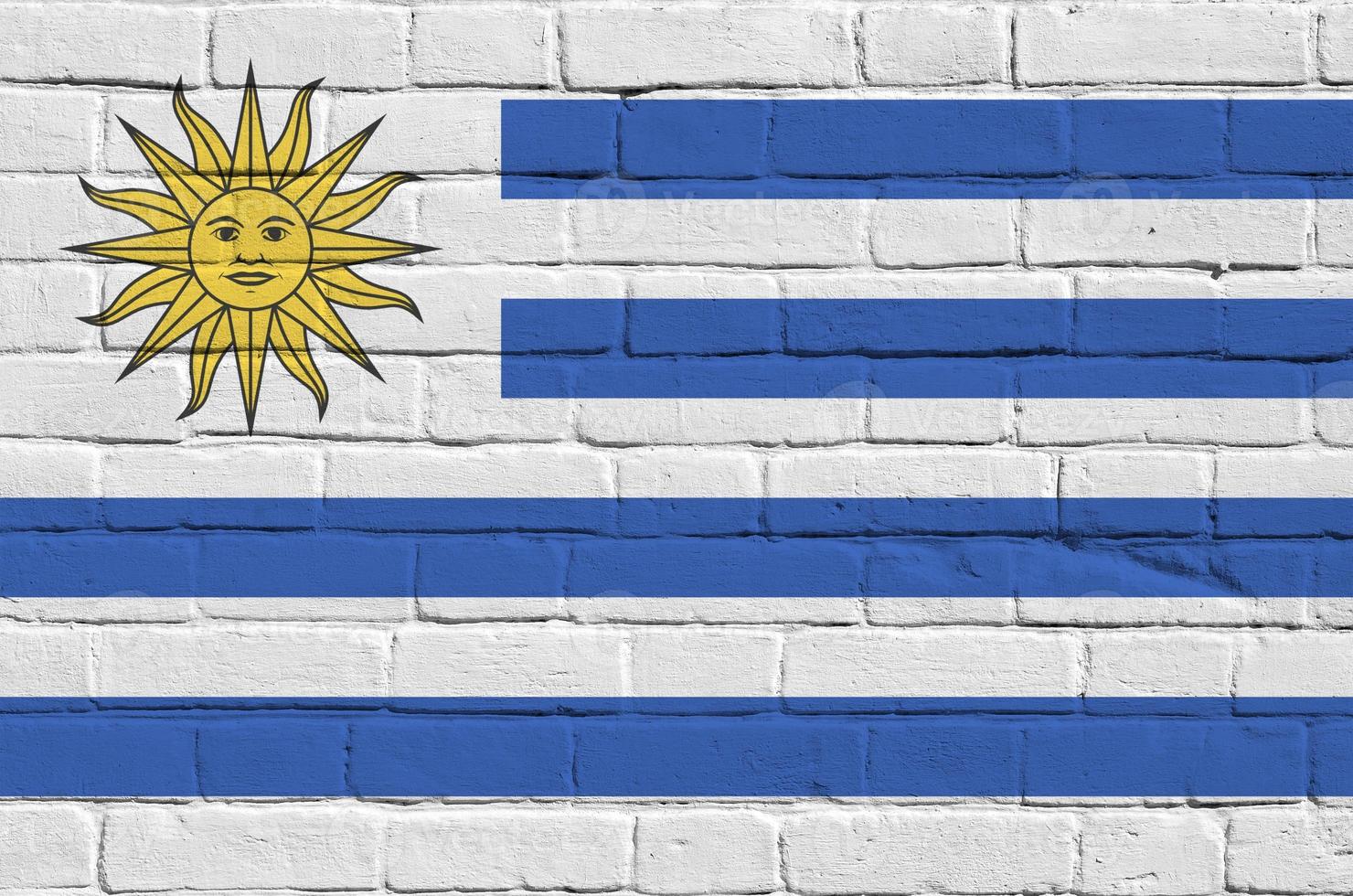 bandera de uruguay representada en colores de pintura en la pared de ladrillo antiguo. banner texturizado sobre fondo de mampostería de pared de ladrillo grande foto