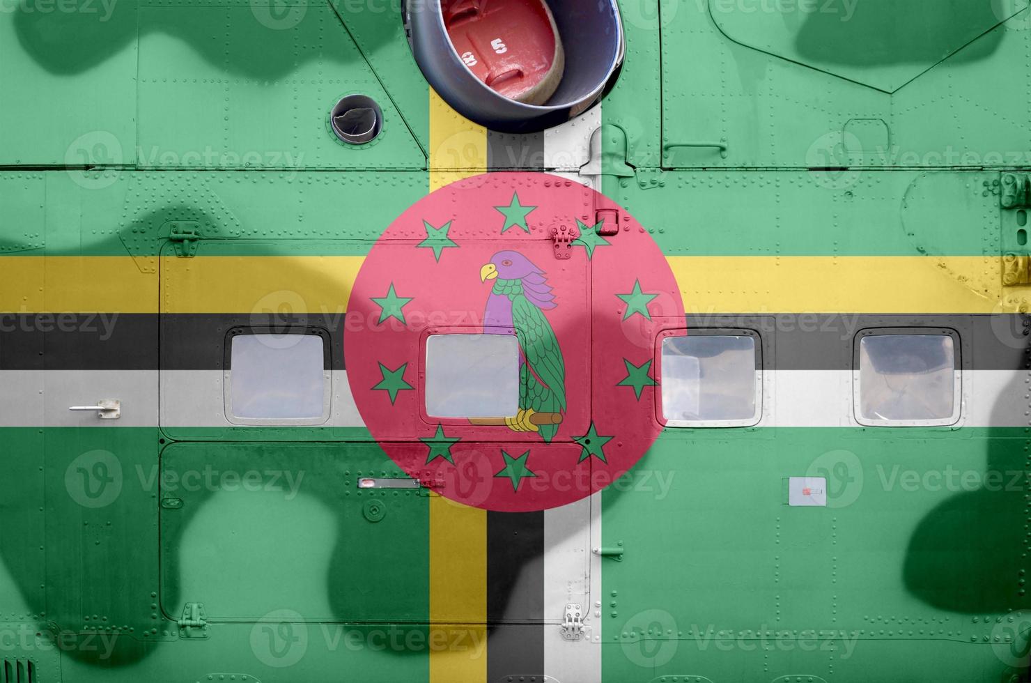 Dominica flag depicted on side part of military armored helicopter closeup. Army forces aircraft conceptual background photo