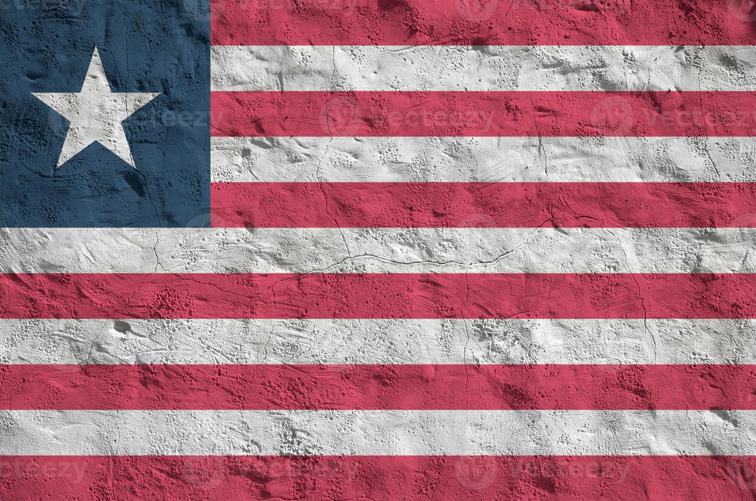 Liberia flag depicted in bright paint colors on old relief plastering wall. Textured banner on rough background photo