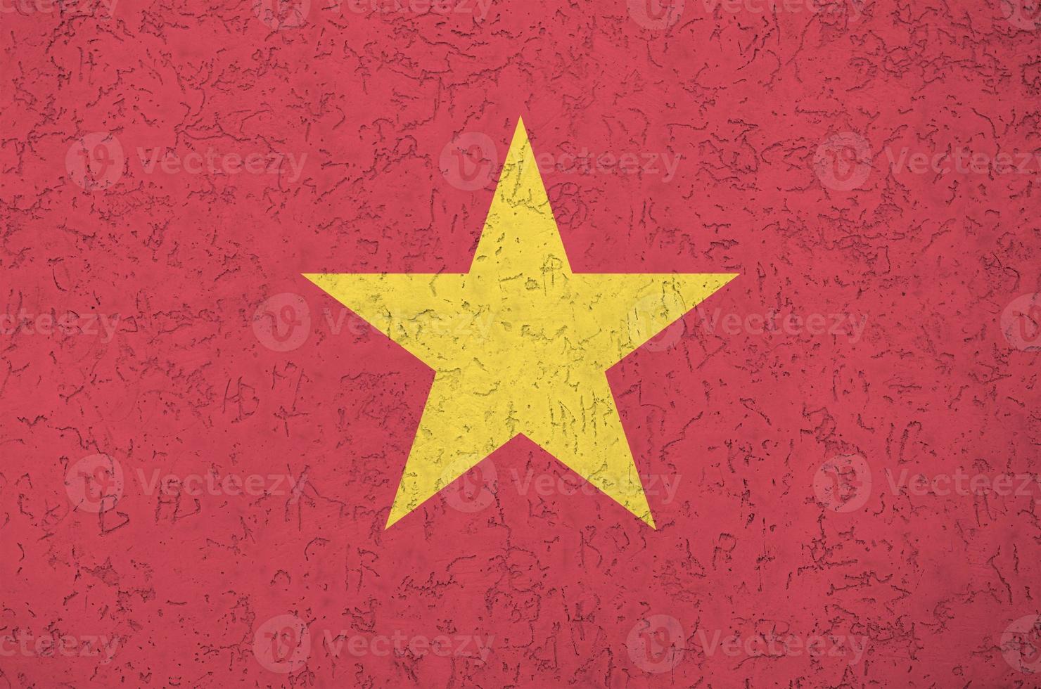 Vietnam flag depicted in bright paint colors on old relief plastering wall. Textured banner on rough background photo