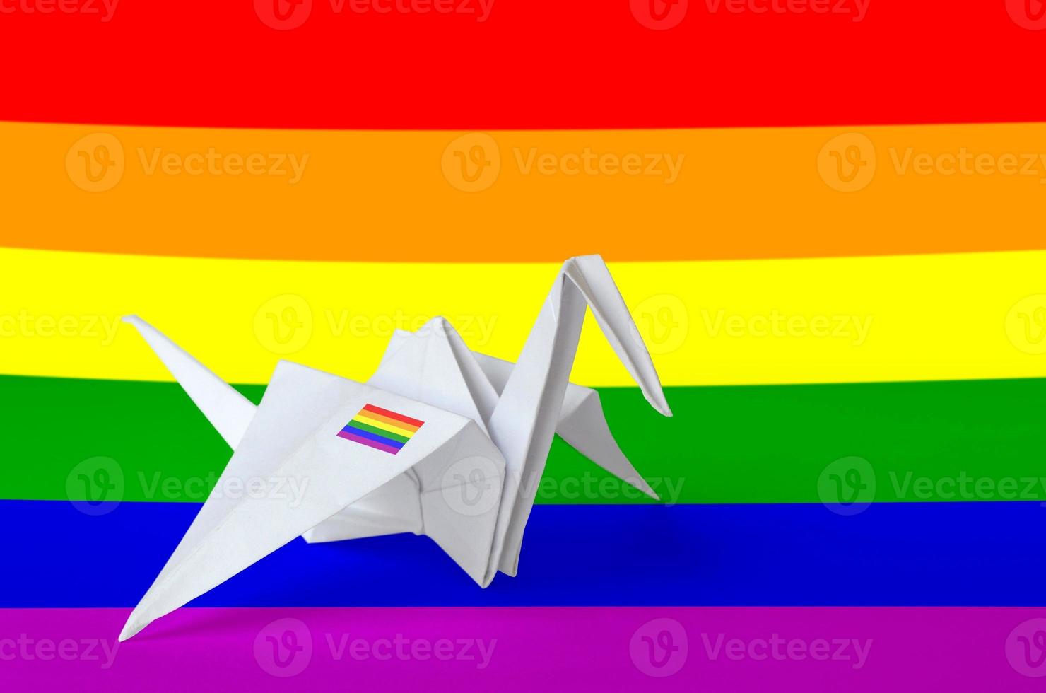 LGBT community flag depicted on paper origami crane wing. Handmade arts concept photo