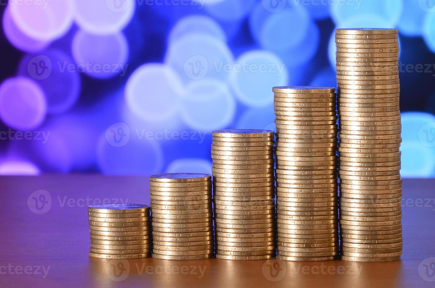 Golden coin stacks arranged as a graph. Increasing columns of coins photo