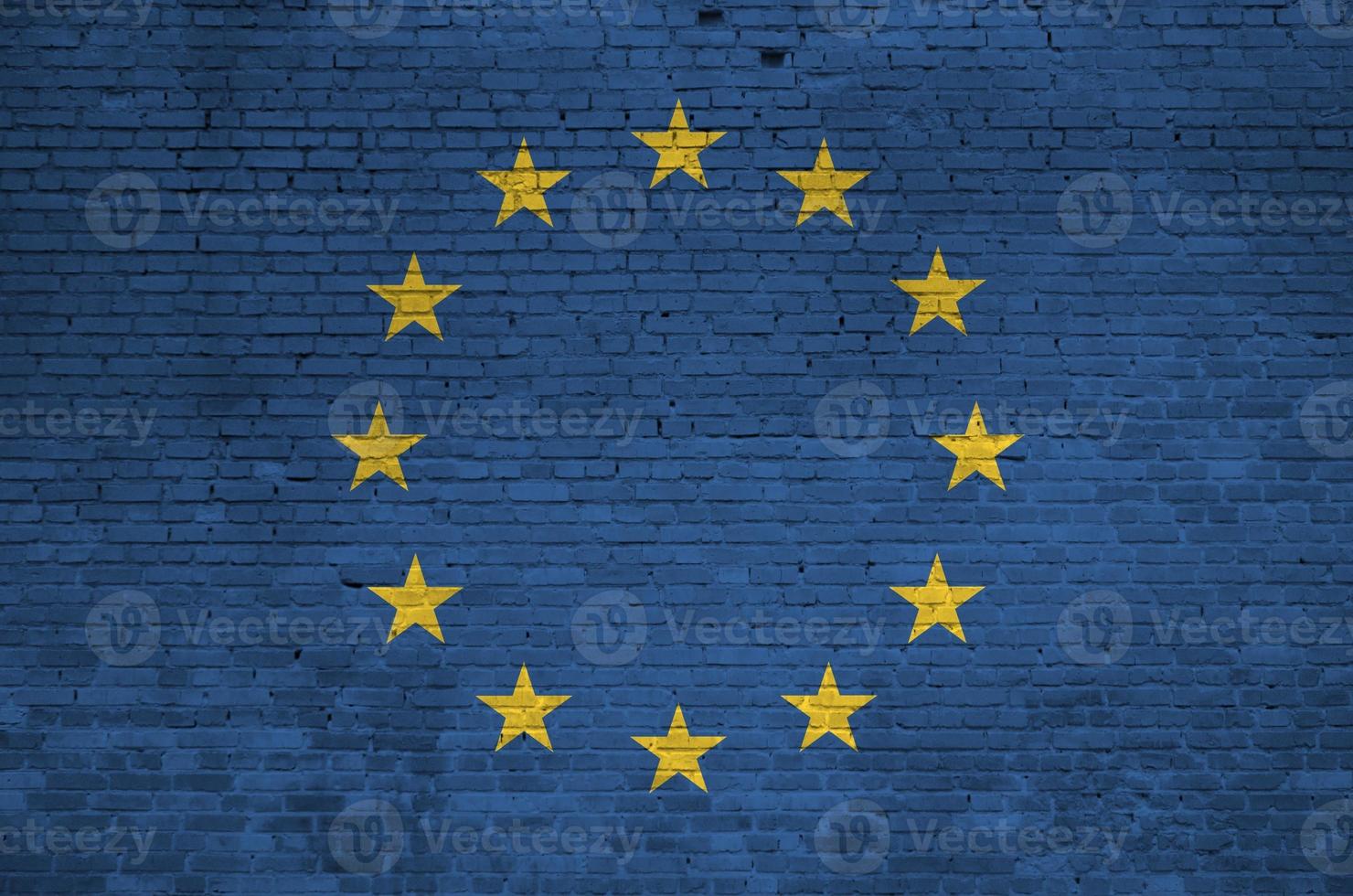 bandera de la unión europea representada en colores de pintura en la pared de ladrillo antiguo. banner texturizado sobre fondo de mampostería de pared de ladrillo grande foto