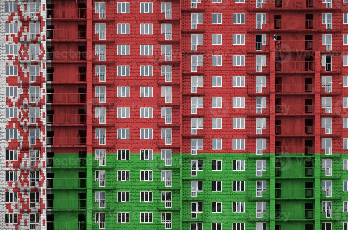 Belarus flag depicted in paint colors on multi-storey residental building under construction. Textured banner on brick wall background photo