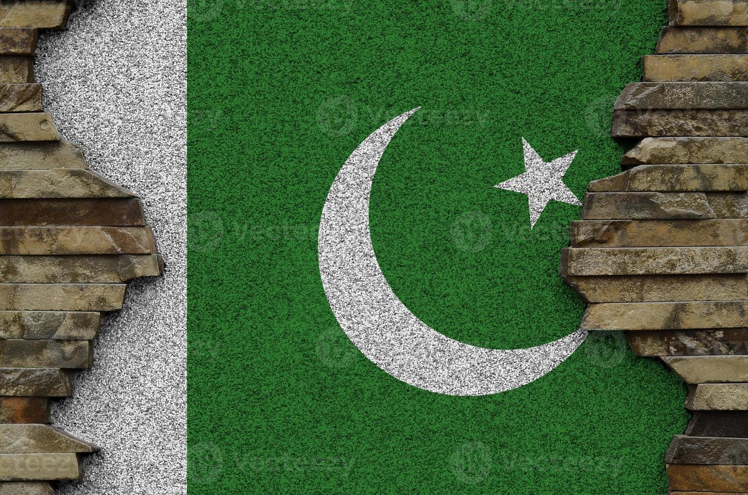 Pakistan flag depicted in paint colors on old stone wall closeup. Textured banner on rock wall background photo
