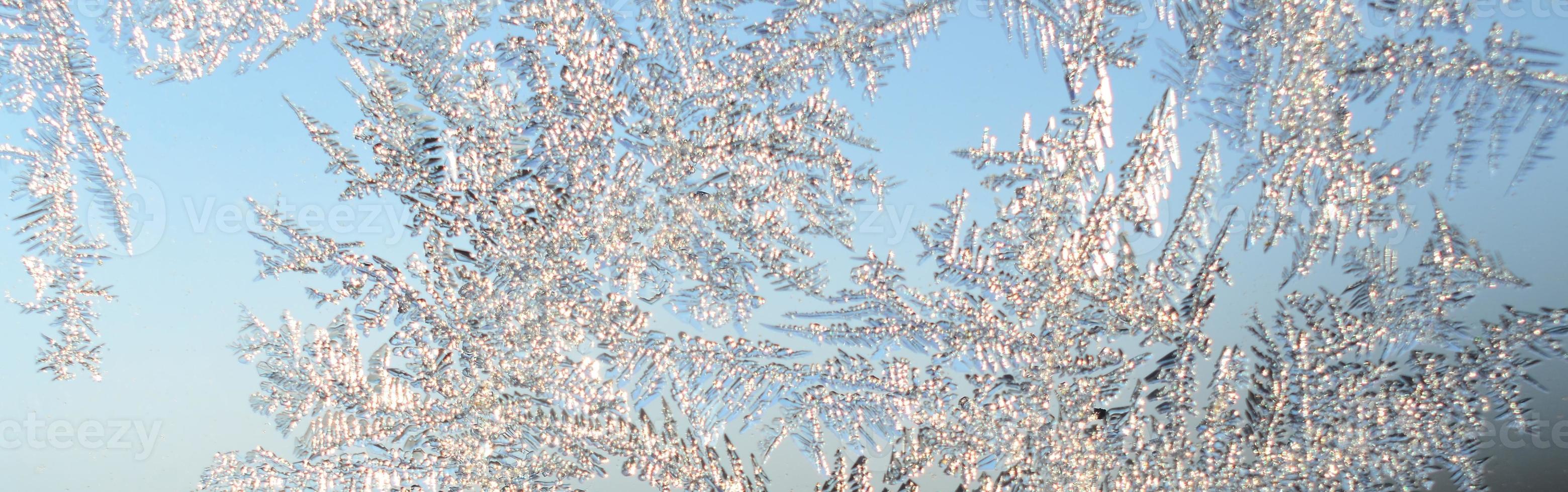 Snowflakes frost rime macro on window glass pane photo