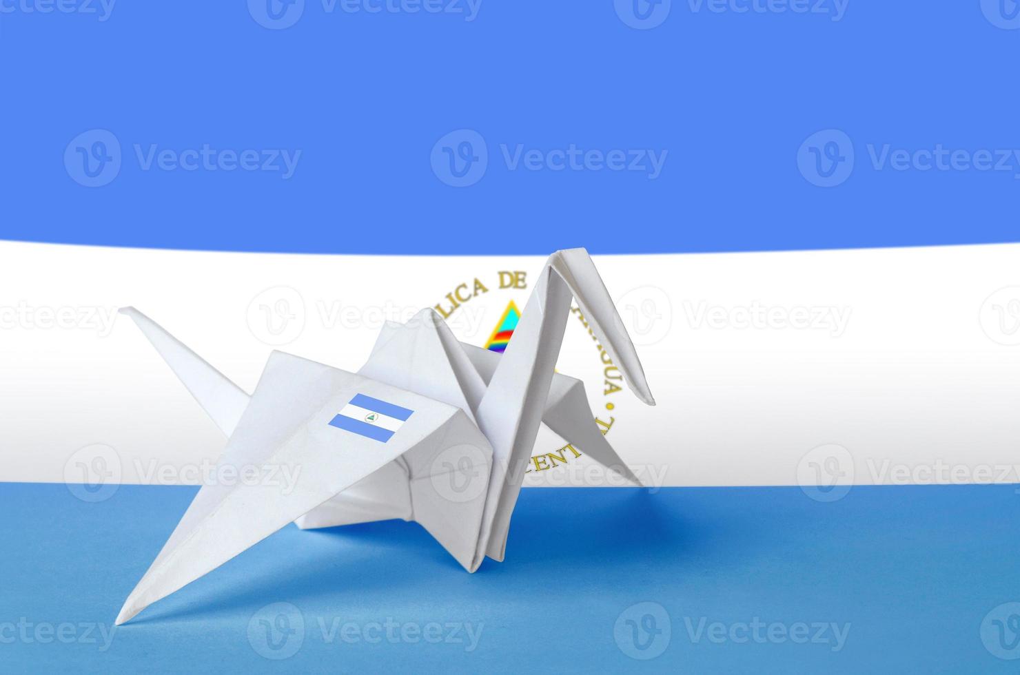 Nicaragua flag depicted on paper origami crane wing. Handmade arts concept photo