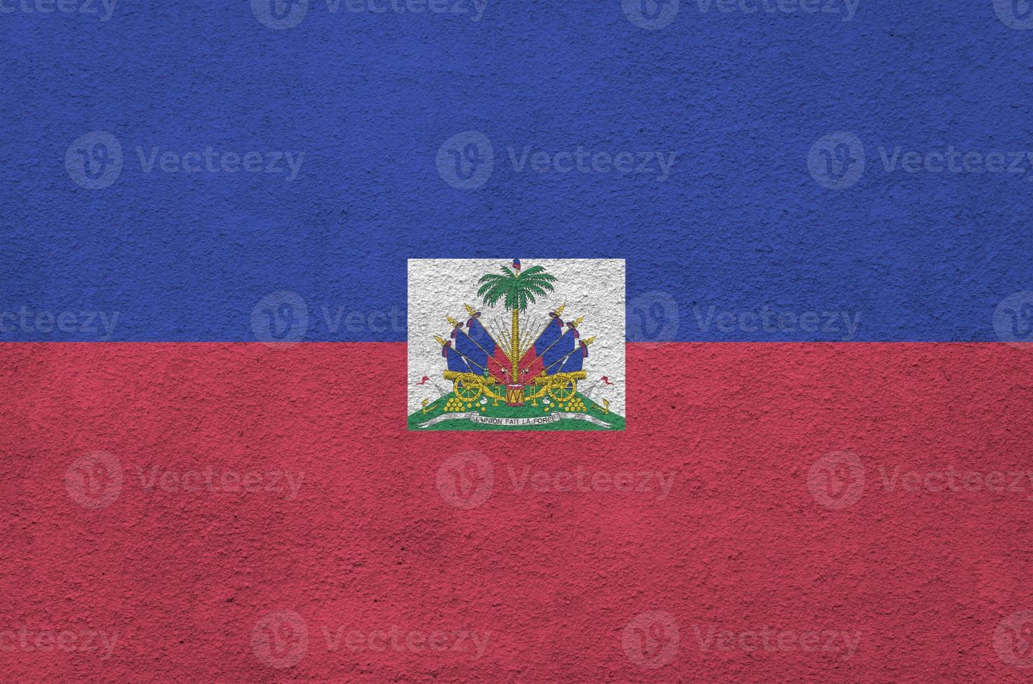 Haiti flag depicted in bright paint colors on old relief plastering wall. Textured banner on rough background photo