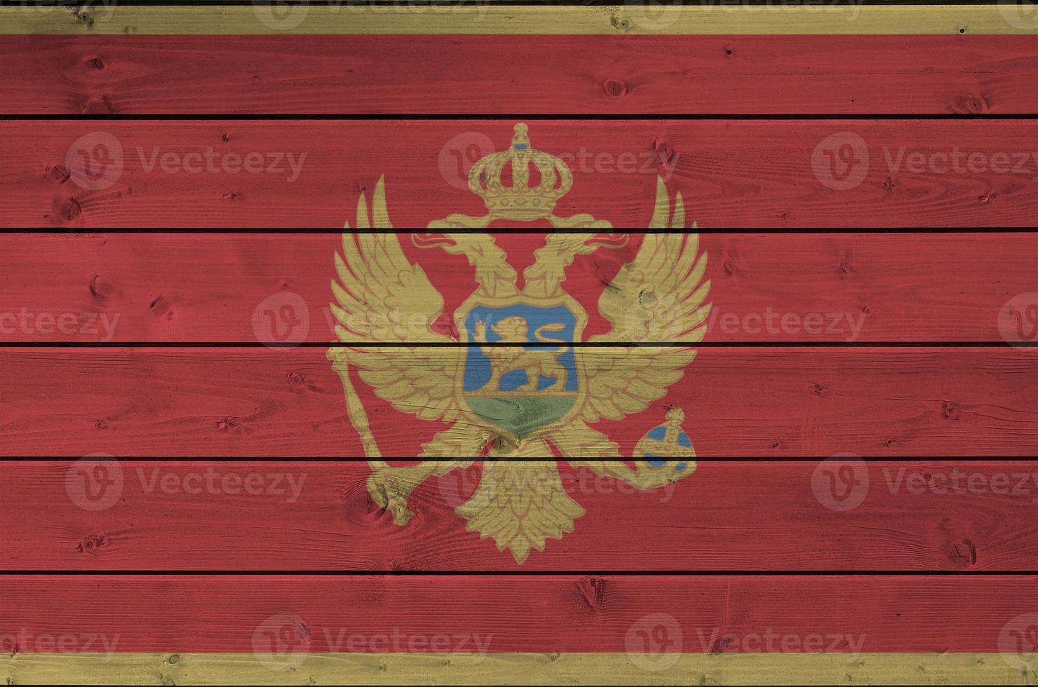 Montenegro flag depicted in bright paint colors on old wooden wall. Textured banner on rough background photo