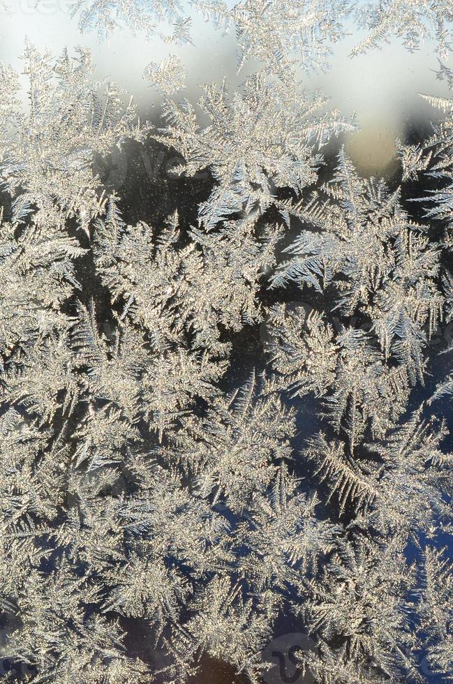 Snowflakes frost rime macro on window glass pane photo