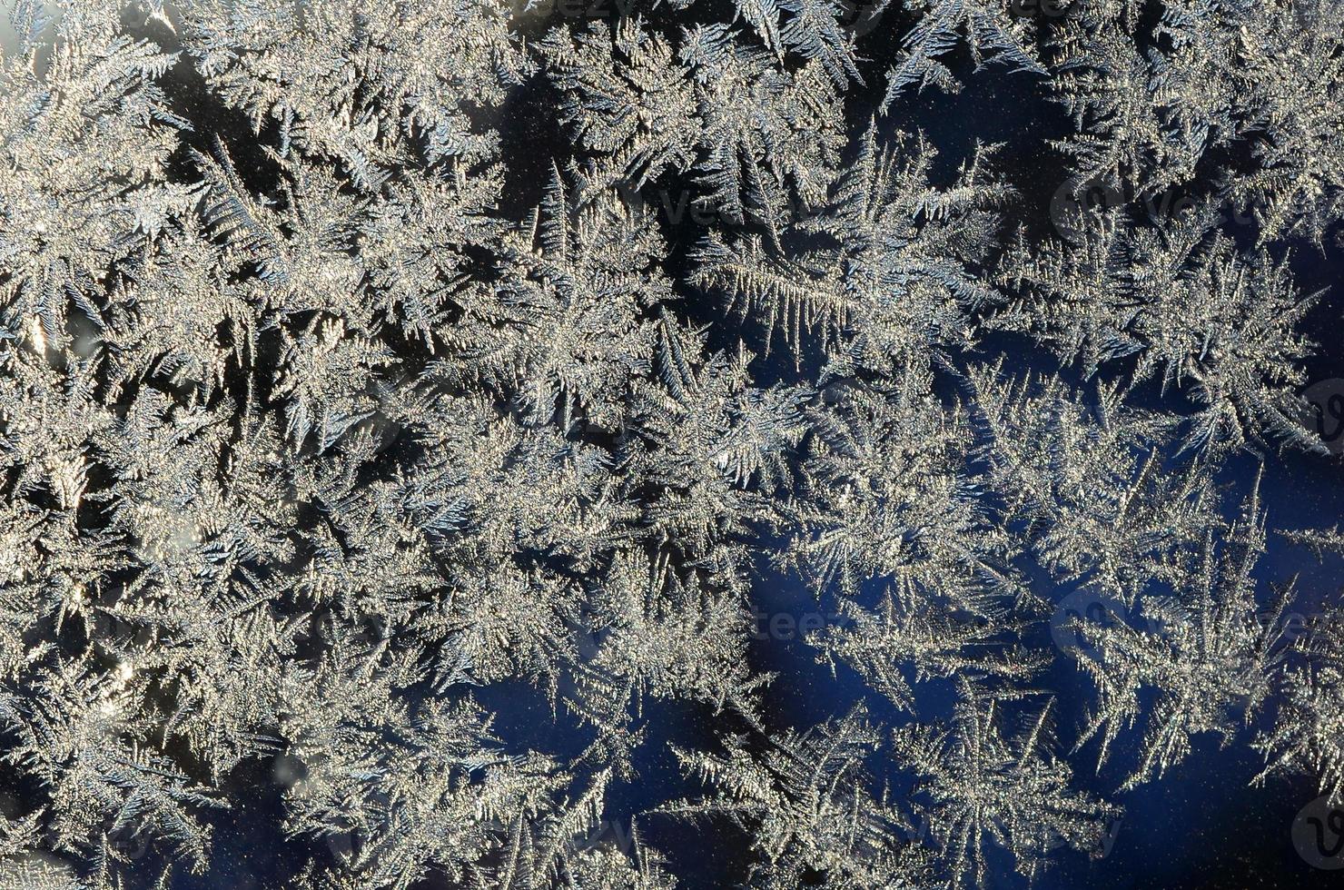 copos de nieve escarcha escarcha macro en el cristal de la ventana foto