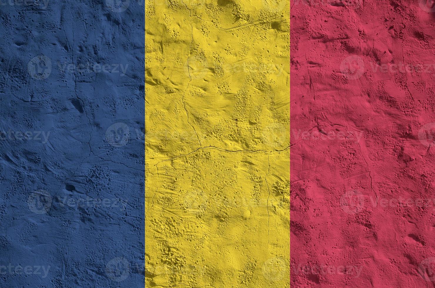 Chad flag depicted in bright paint colors on old relief plastering wall. Textured banner on rough background photo