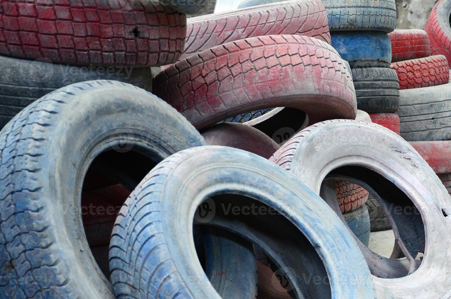 A picture of many old used tires left on a waste dump photo