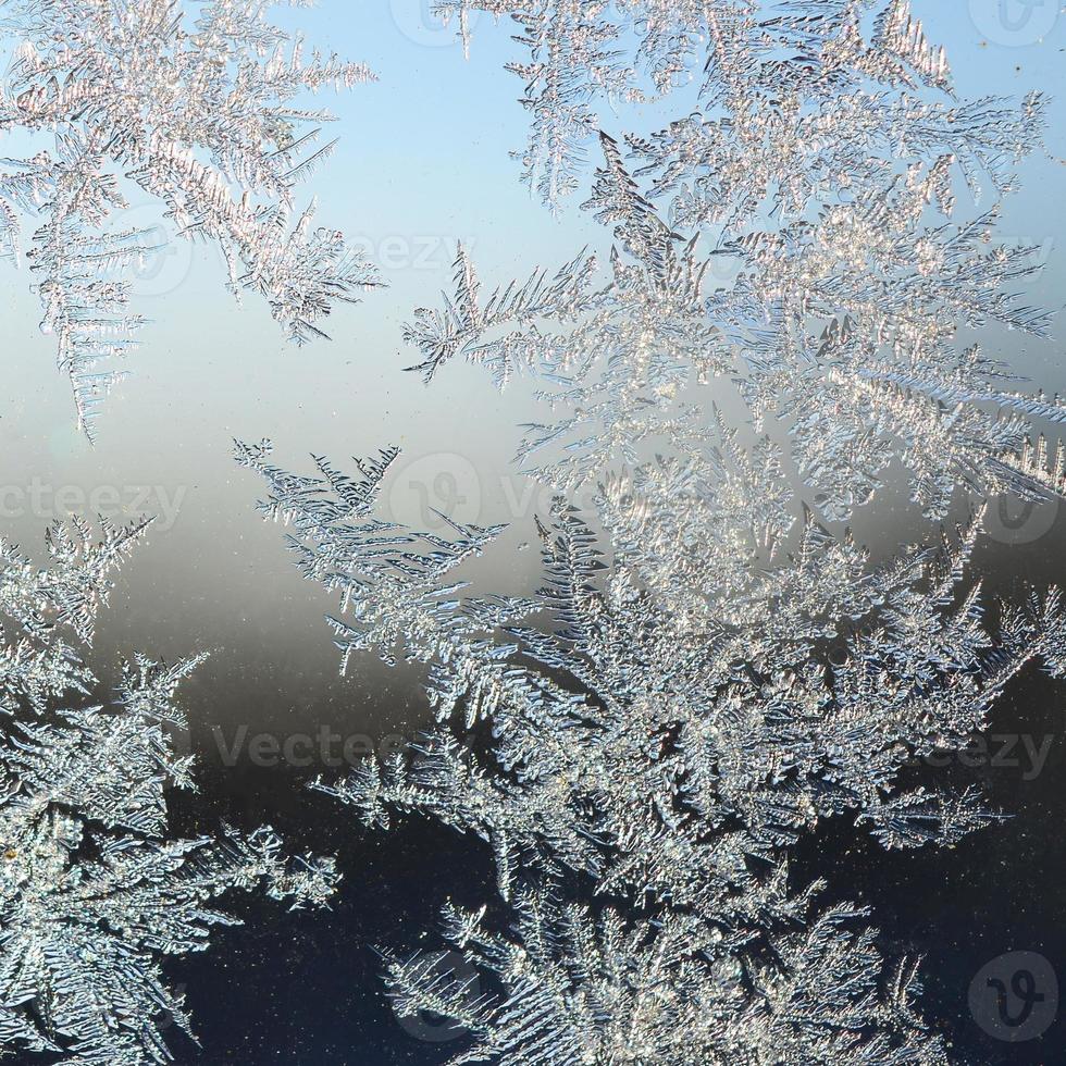 Snowflakes frost rime macro on window glass pane photo