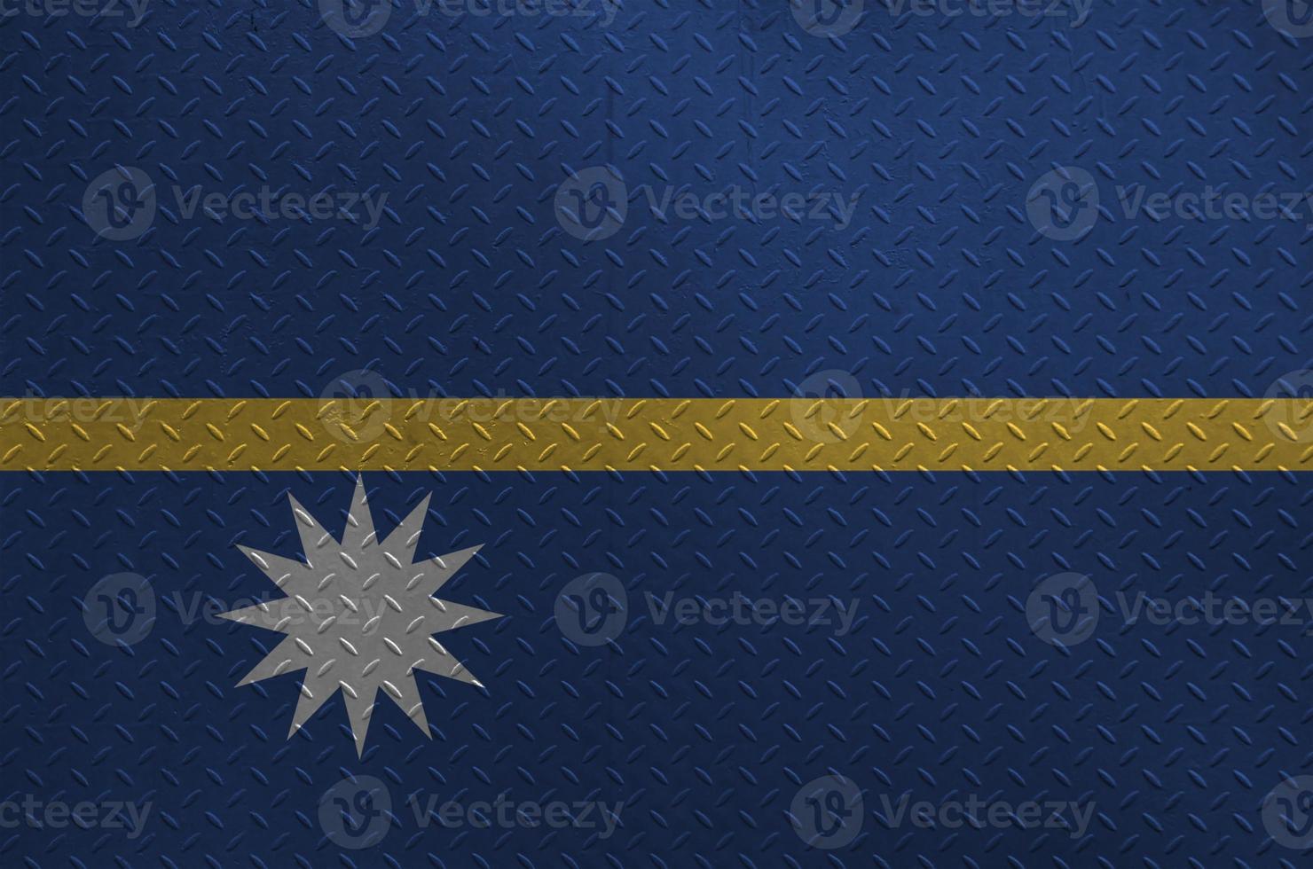 Nauru flag depicted in paint colors on old brushed metal plate or wall closeup. Textured banner on rough background photo