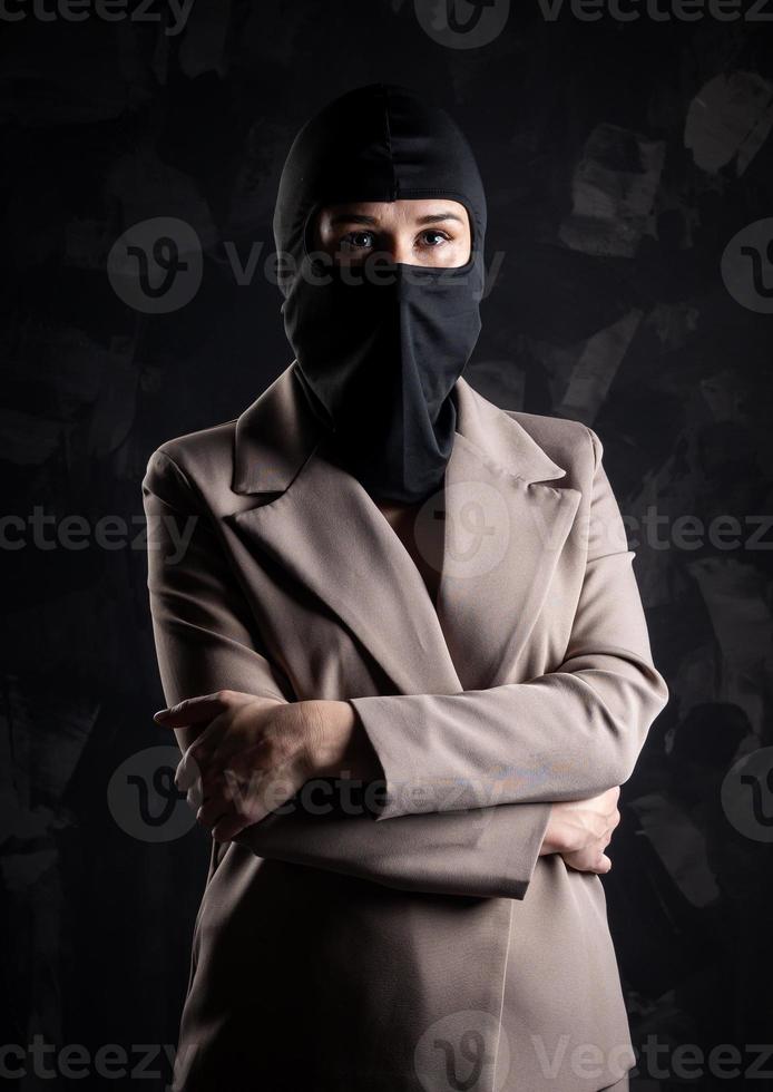 Portrait of a girl in a black balaclava and beige coat. photo