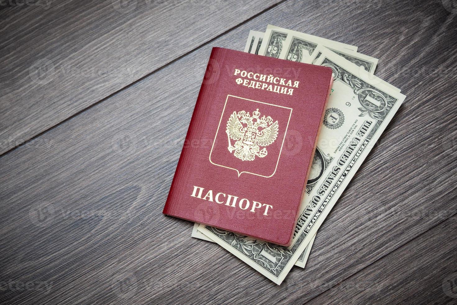 A foreign passport and dollars on a wooden background. photo