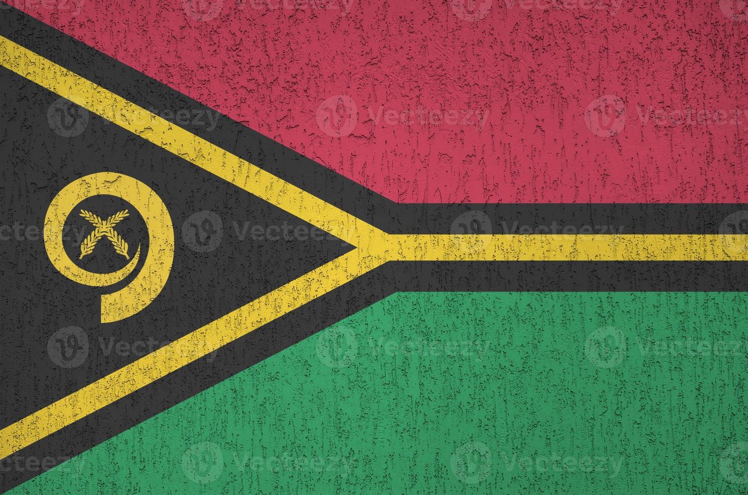 Vanuatu flag depicted in bright paint colors on old relief plastering wall. Textured banner on rough background photo