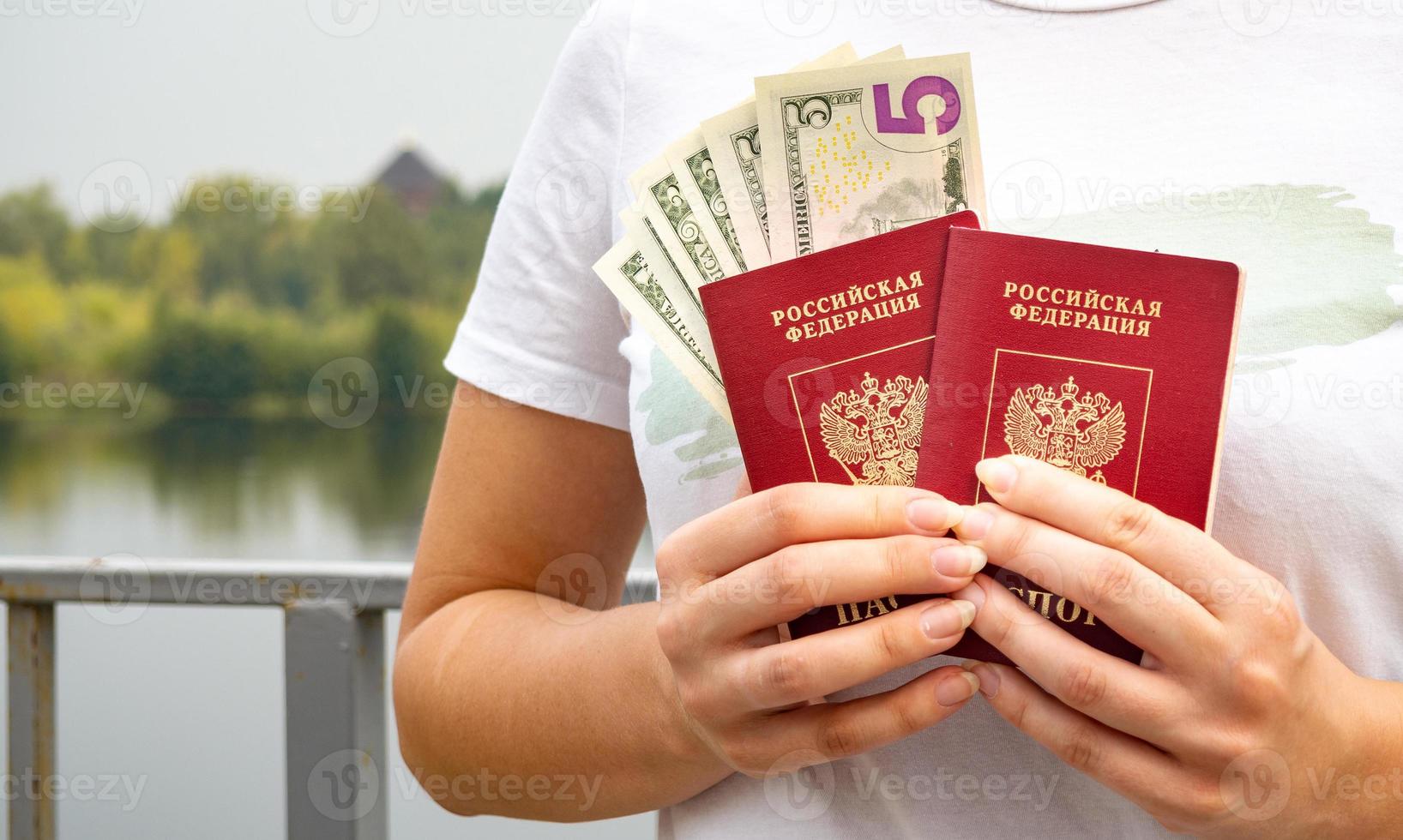 A foreign passport and dollars in your hand, against the background of nature. photo