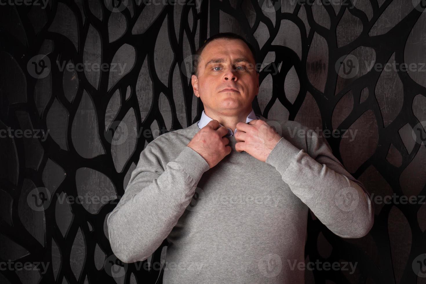 un hombre guapo con traje posa en un estudio interior. foto