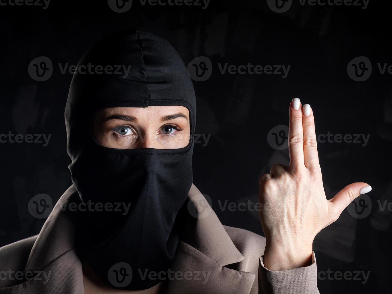 Portrait of a girl in a black balaclava and beige coat. photo