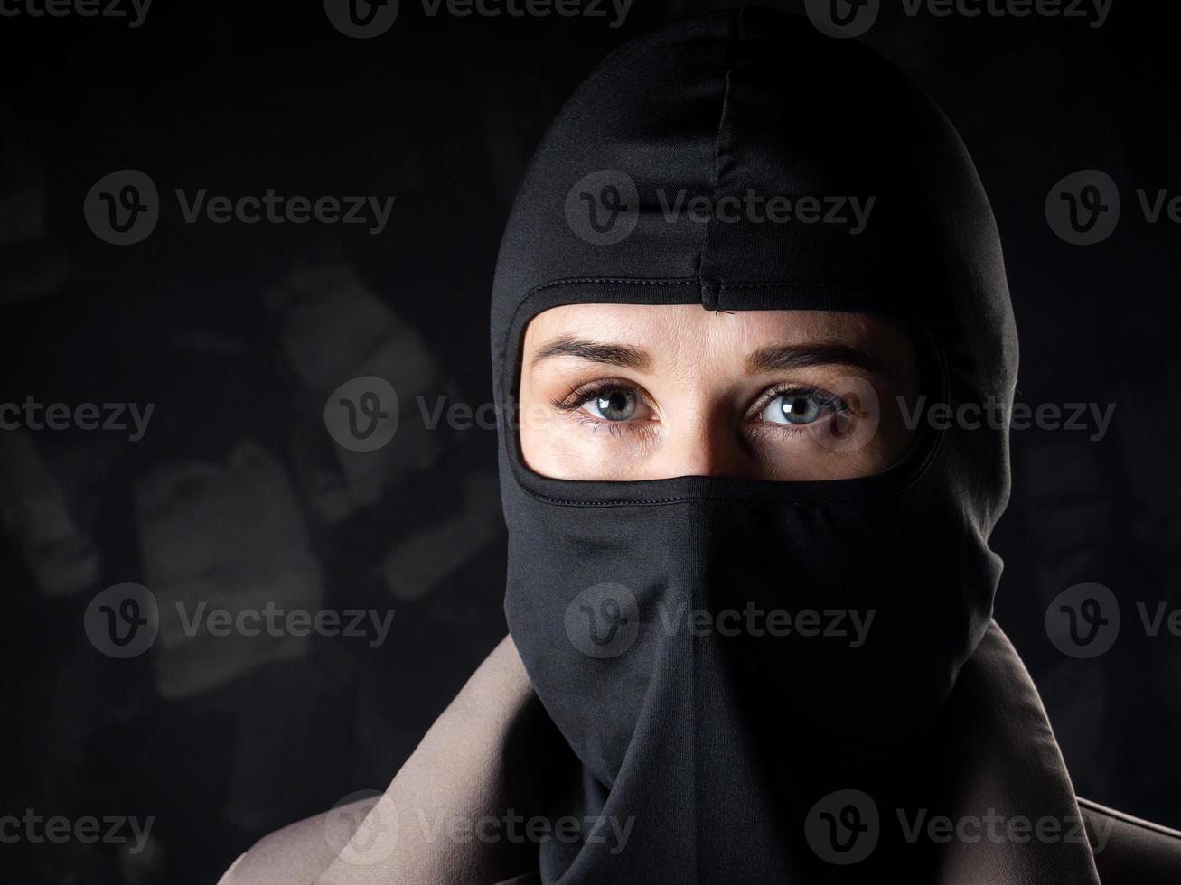 Portrait of a girl in a black balaclava and beige coat. photo