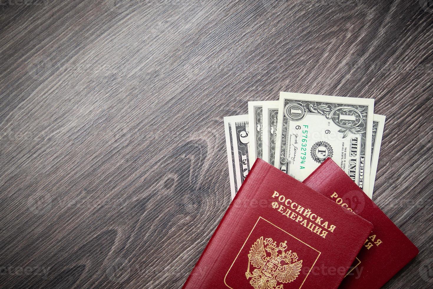 A foreign passport and dollars on a wooden background. photo