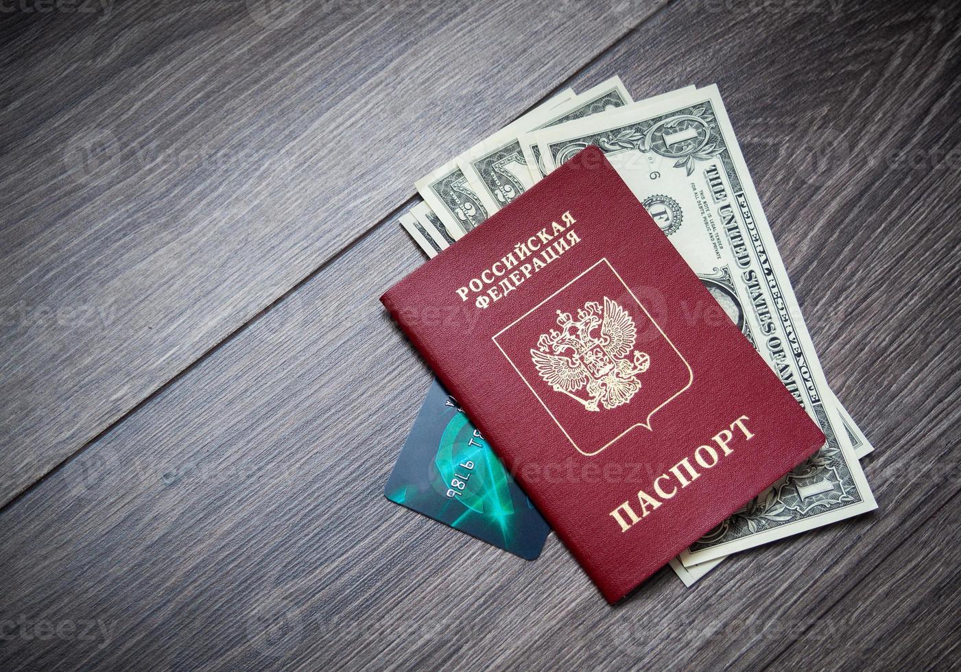 A foreign passport and dollars on a wooden background. photo