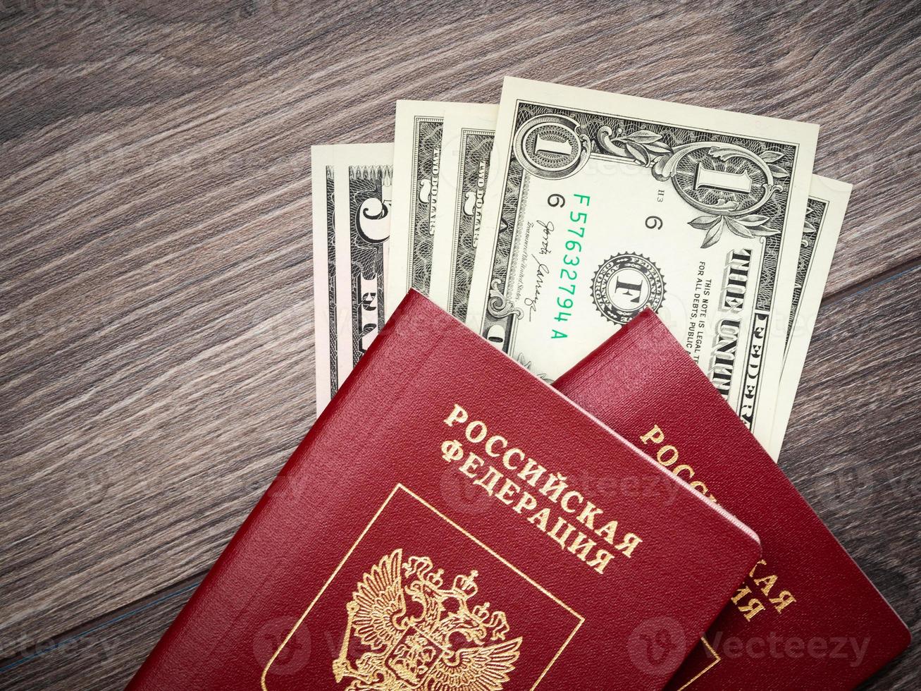 A foreign passport and dollars on a wooden background. photo