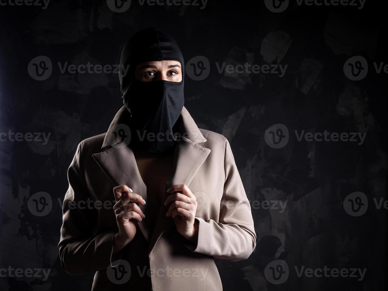 Portrait of a girl in a black balaclava and beige coat. photo