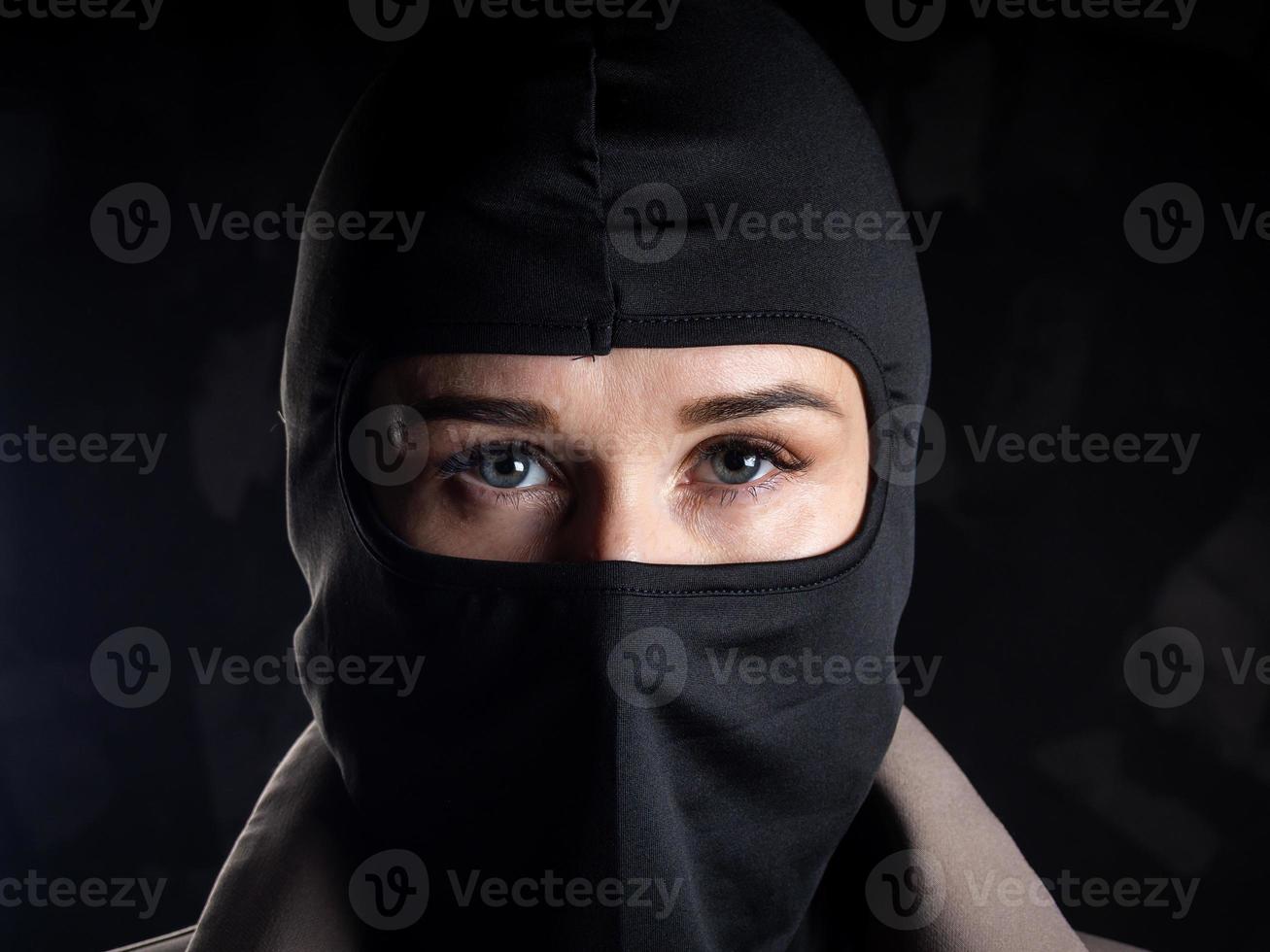 Portrait of a girl in a black balaclava and beige coat. photo