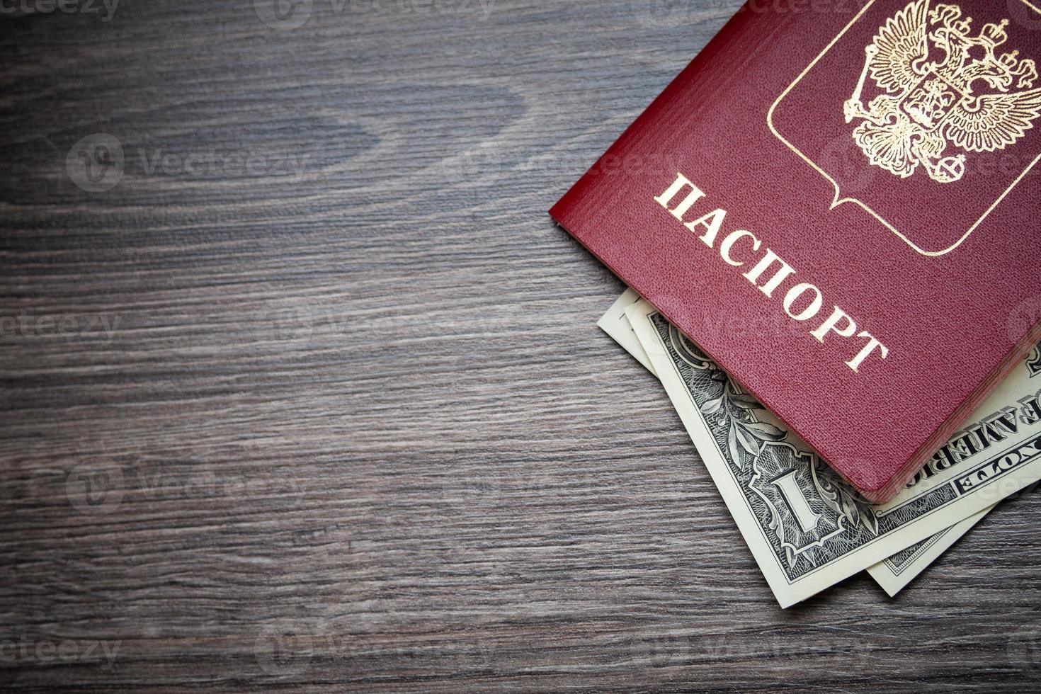 A foreign passport and dollars on a wooden background. photo