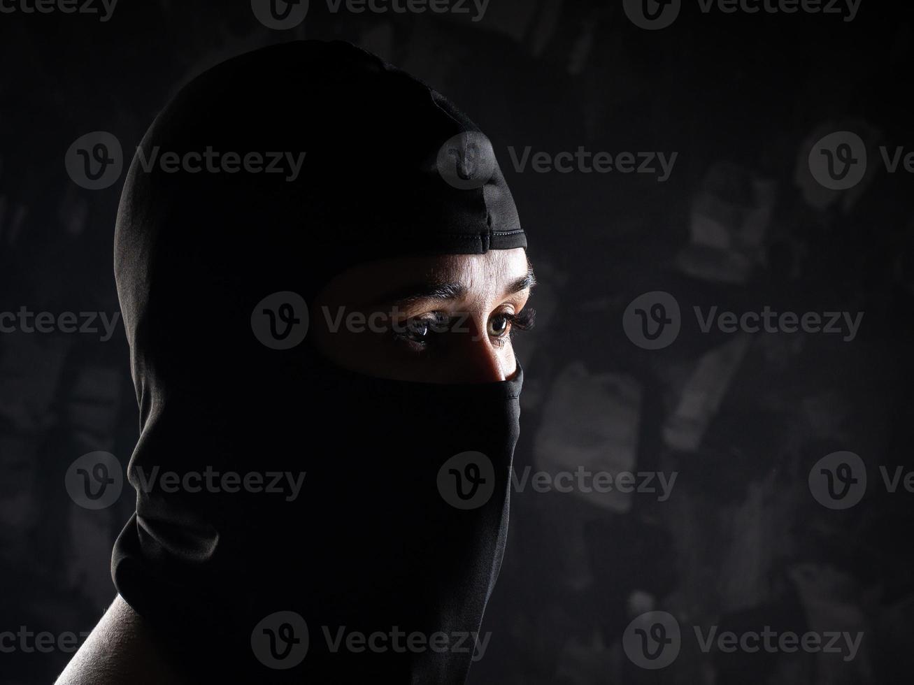 retrato de una niña con un pasamontañas negro y un sostén negro. foto