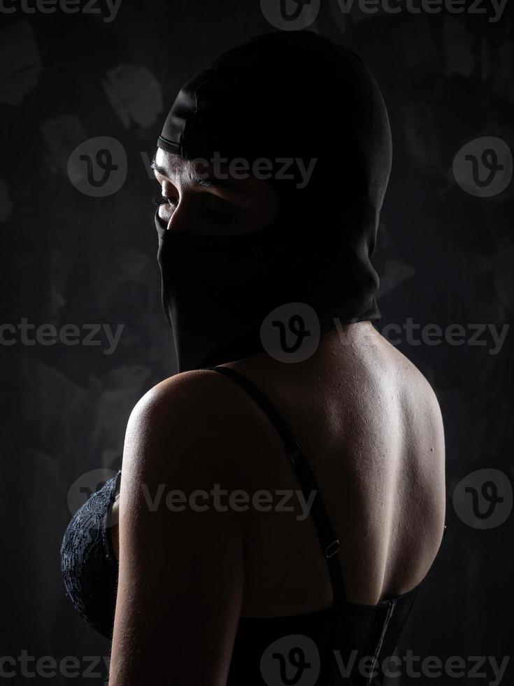 Portrait of a girl in a black balaclava and a black bra. photo