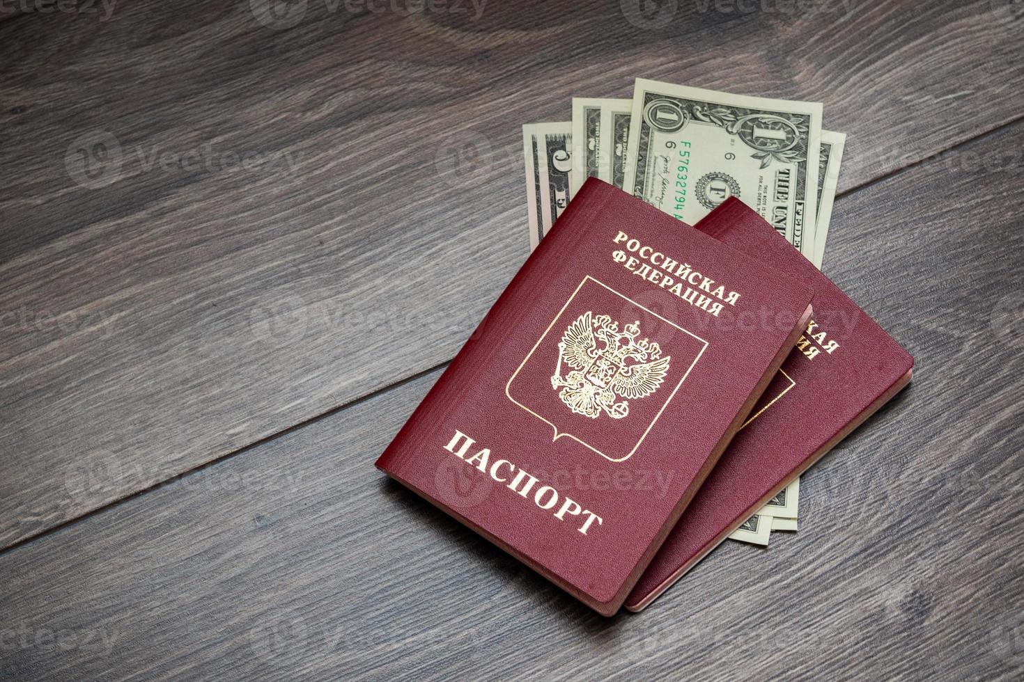 A foreign passport and dollars on a wooden background. photo