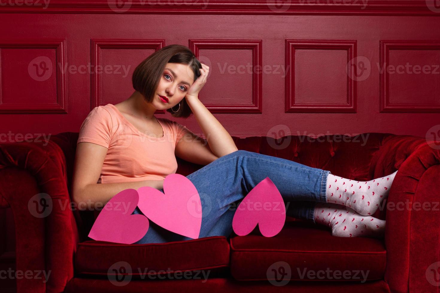 Women on couch with three heart shapes in front of her photo