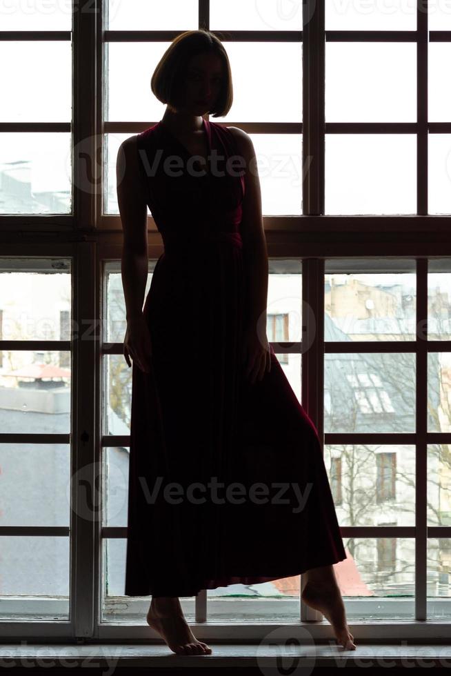 Woman silhouette in front of window photo