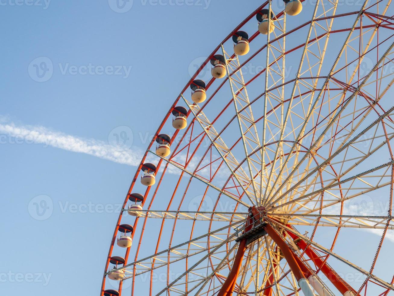 Ferris wheel against the sky. Amusement park by the sea. Rest zone. Round mechanism. Height lovers. photo