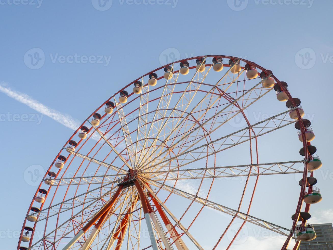 Ferris wheel against the sky. Amusement park by the sea. Rest zone. Round mechanism. Height lovers. photo