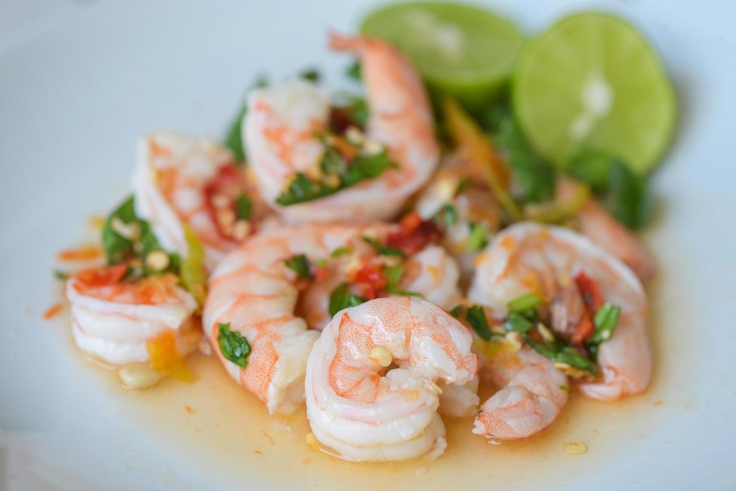 Fresh shrimp on white plate and fresh vegetables, cooked shrimps prawns and seafood spicy chili sauce coriander, cooking shrimp salad lemon lime photo